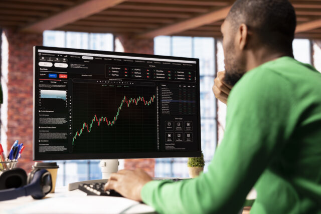 Day trader using computer, purchasing stocks that might perform well